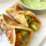 marinated chicken is rolled into cooked parathas