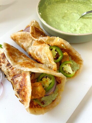marinated chicken is rolled into cooked parathas