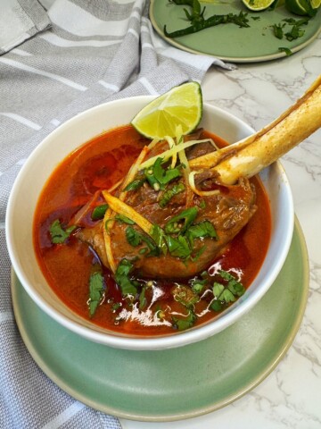 Lamb shanks are cooked with spices until soft and fall off the bones