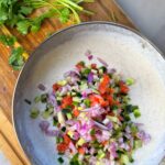 A combination of yogurt, chopped veggies and spices, served with a variety of dishes