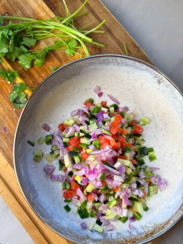A combination of yogurt, chopped veggies and spices, served with a variety of dishes
