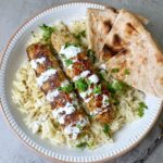 ground chicken kebabs served with white rice, white sauce and naan