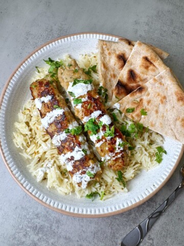 ground chicken kebabs served with white rice, white sauce and naan