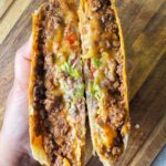 A seasoned beef crunchwrap in a taco bell style with crunch tostadas and fresh veggies.