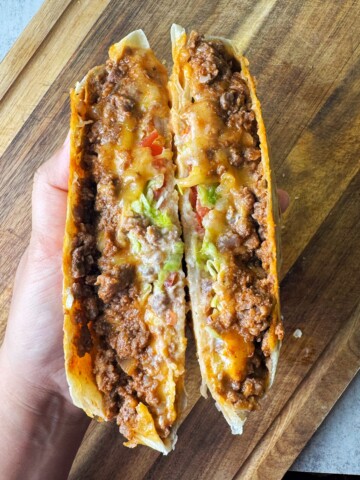 A seasoned beef crunchwrap in a taco bell style with crunch tostadas and fresh veggies.