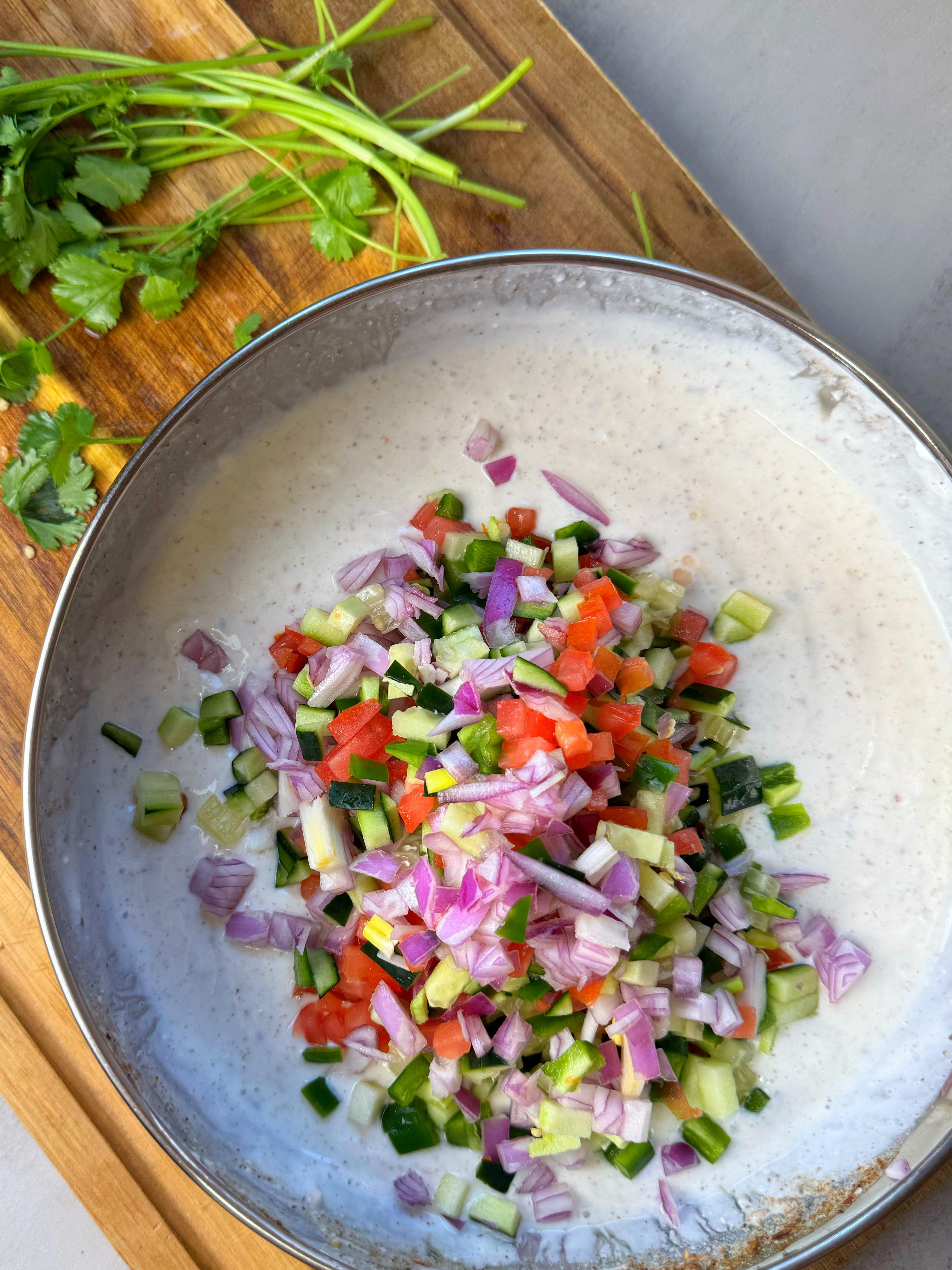 A combination of yogurt, chopped veggies and spices, served with a variety of dishes