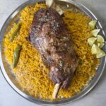 A platter of flavored rice with fall of the bone lamb sajji