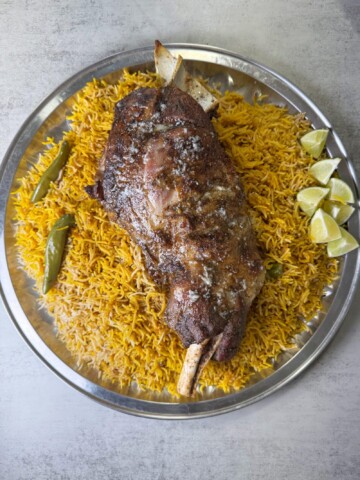 A platter of flavored rice with fall of the bone lamb sajji