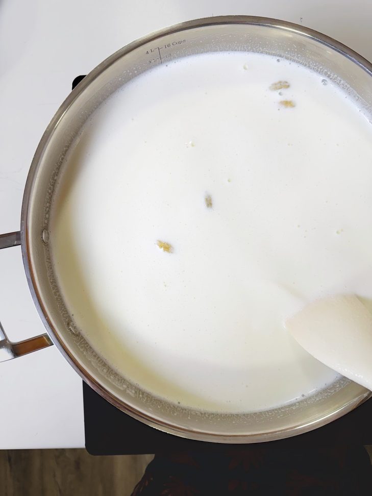 A pot of milk simmering on low heat